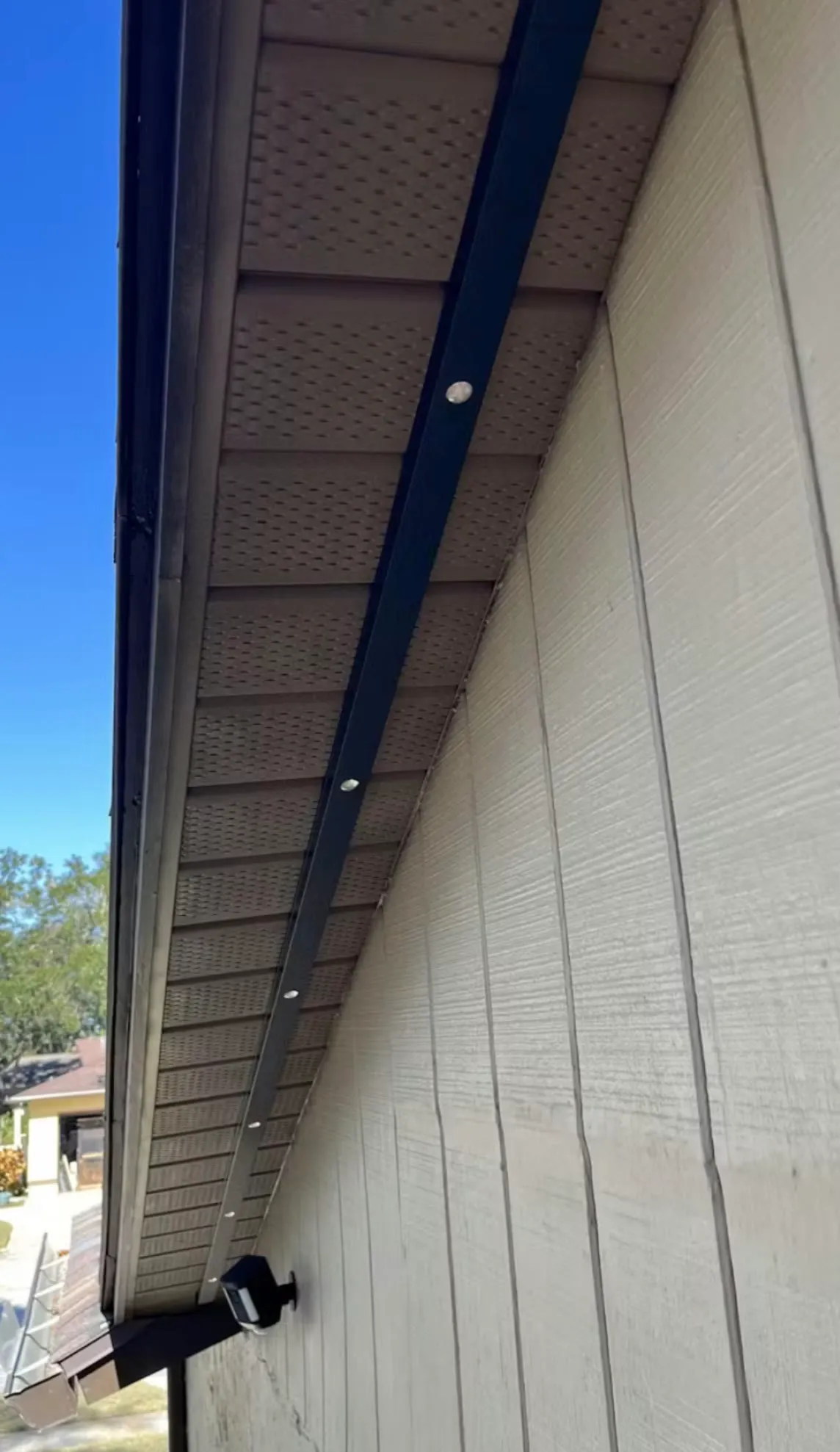 Permanent light track under a roof eave in daylight, lights off