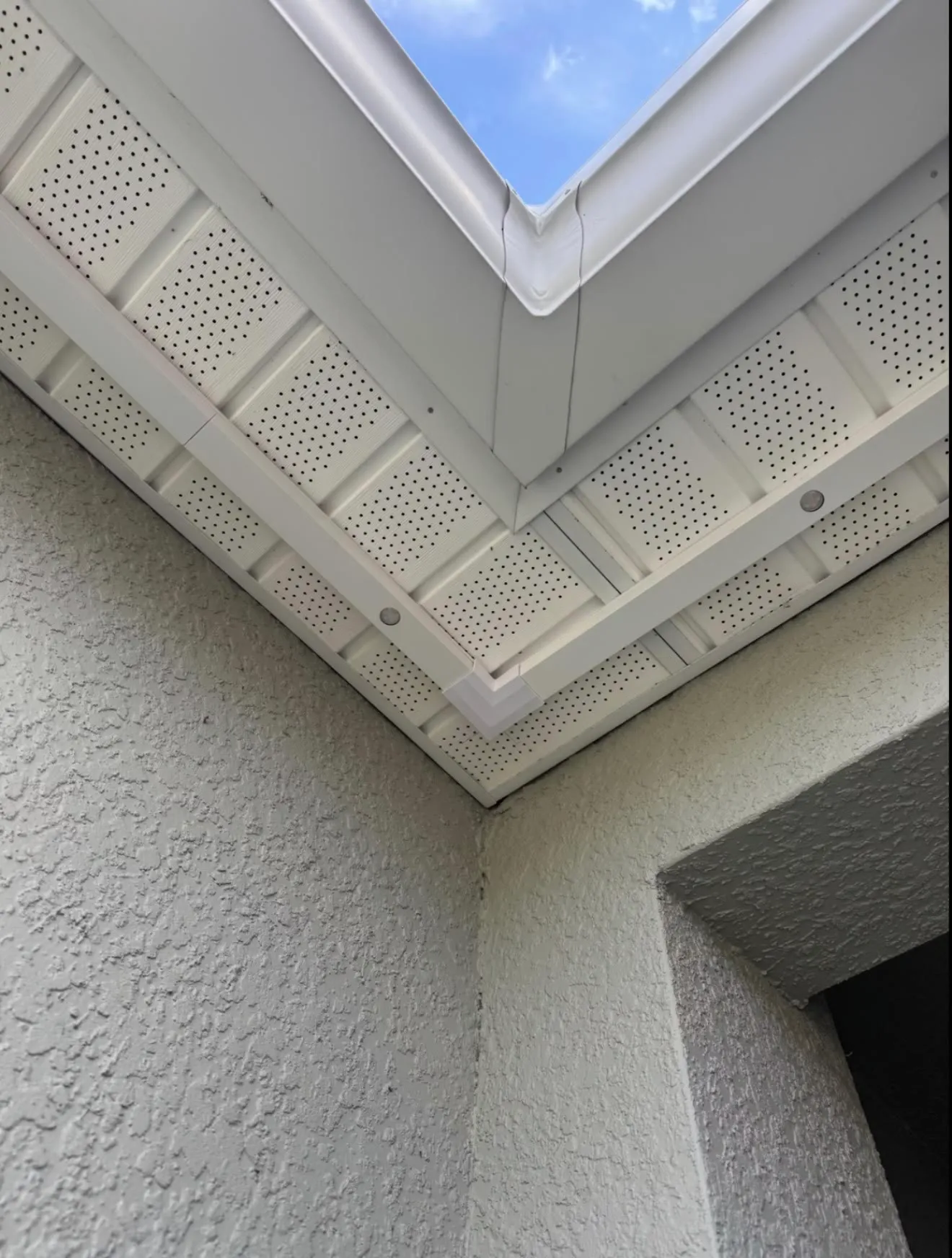 White permanent light track along a white soffit corner in daylight